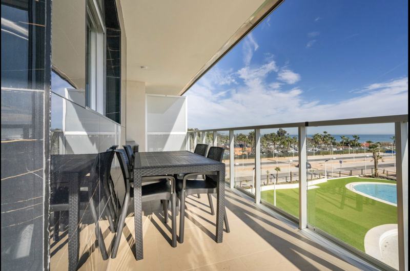 Mesa de comedor en la terraza con vistas a la piscina y al mar