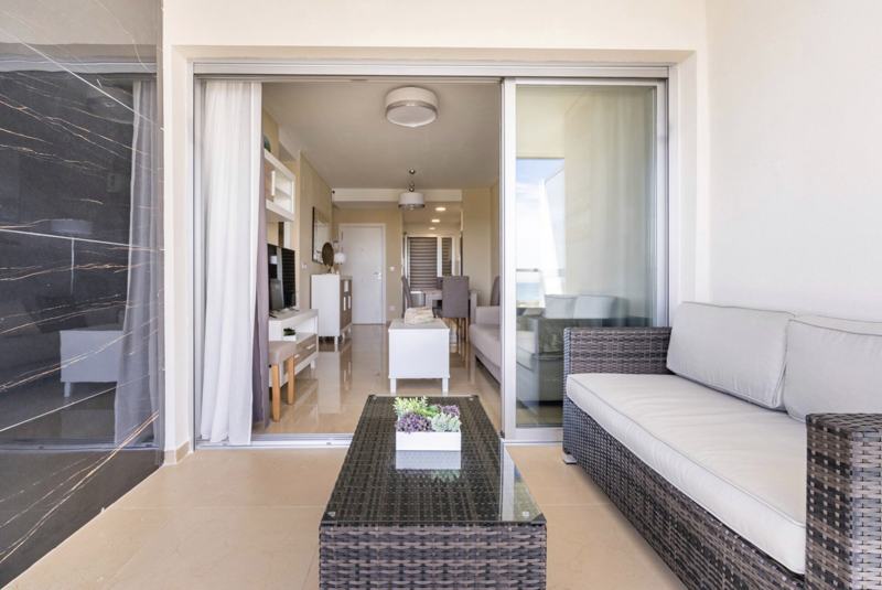 Terraza con sofá de exterior abierta al salón